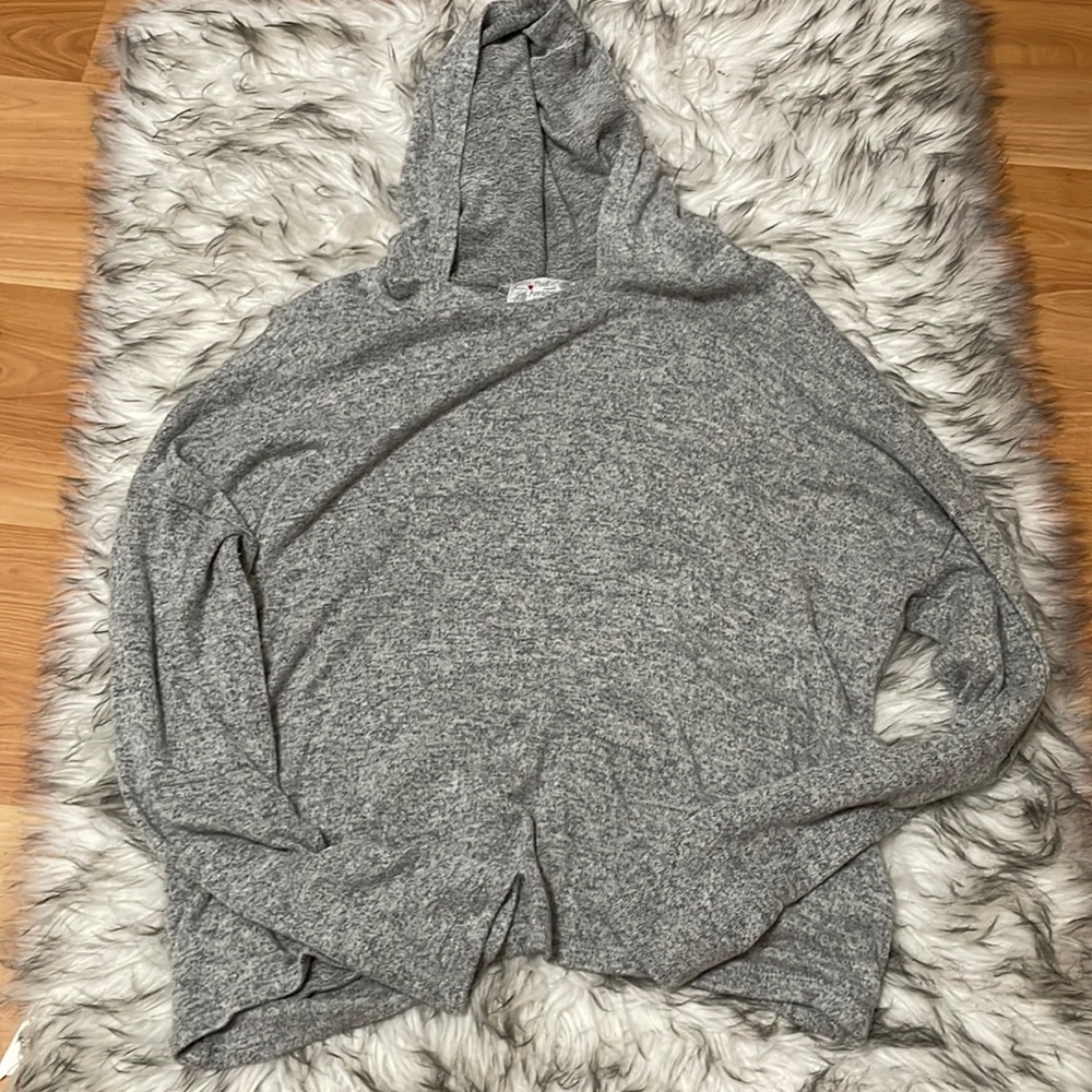 A grey long sleeved sweater, with a open crossed back